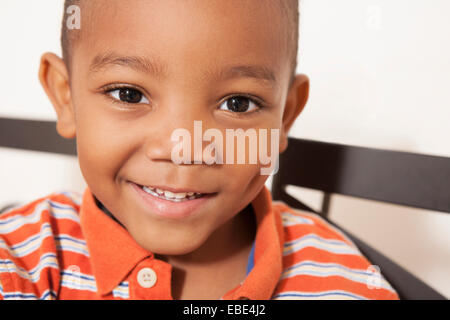 Close-up portrait of African-American boy, smiling and looking at camera, USA