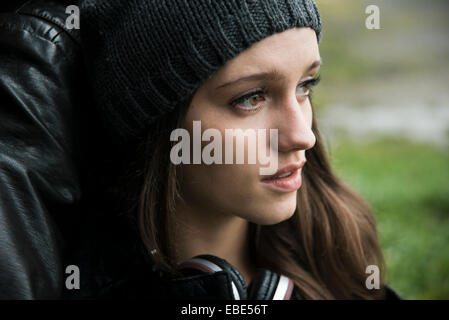 Close-up portrait of teenage girl outdoors, wearing hat and headphones around neck, Germany Stock Photo