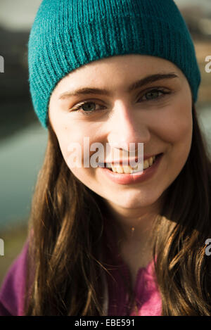 Close-up portrait of teenage girl outdoors wearing toque, smiling and looking at camera, Germany Stock Photo