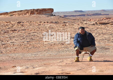 Navajo Indian sitting on a stool off Highway 89, Arizona. Stock Photo