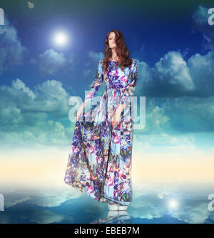 Imagination. Woman in Light Dress is Hovering among Clouds Stock Photo