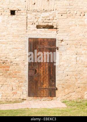 Closed antique wooden door on brick wall Stock Photo