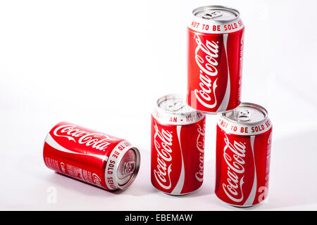 Four cans of coca cola drinks on a white background Stock Photo