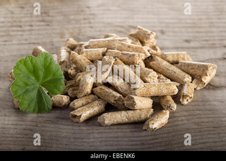 Close up of extruded wood pellets on wooden background Stock Photo