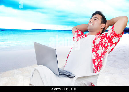 indian man beach Laptop Working Stock Photo
