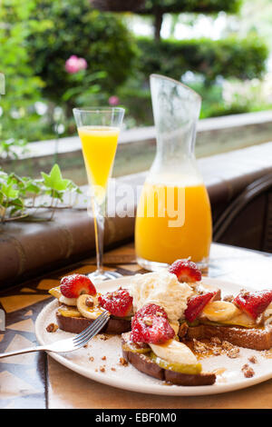 French toast and mimosa at brunch in garden patio setting Stock Photo ...