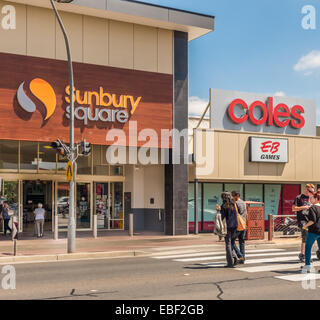 People crossing street under Coles and EB store signs in Sunbury, Victoria, Australia Stock Photo