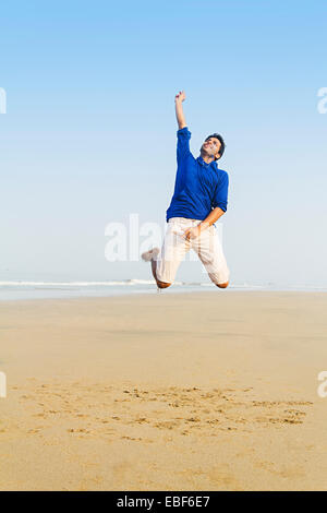 indian man Sea Side Jumping Stock Photo