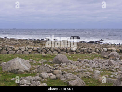 A dark day with autumn or winter storms on Jaeren, west coast of Norway near Stavanger waves breaking over stones and beach Stock Photo