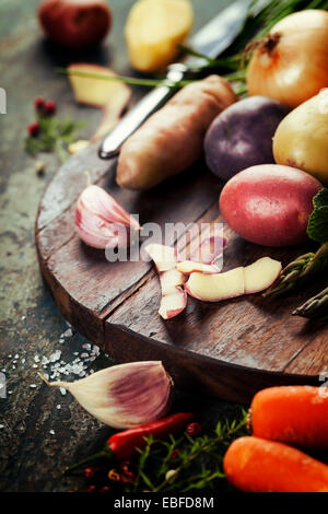 Raw colorful potatoes and vegetables ready for cooking. Fresh organic vegetables. Food background. Healthy food from garden Stock Photo