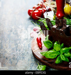 vintage herb cutting mezzaluna knife and fresh ingredients. Health, vegetarian food or cooking concept Stock Photo