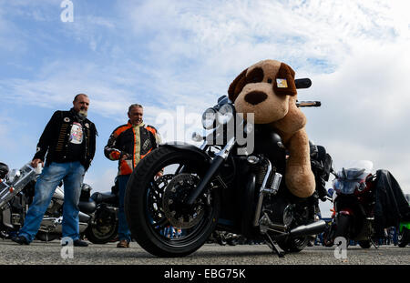 (141201) -- JOHANNESBURG, Dec. 1, 2014 (Xinhua) -- Two participants look at a motorcycle carrying a toy before the Toy Run in Johannesburg, South Africa, on Nov. 30, 2014. The annual motorcycle charity ride of South Africa, Toy Run, was held in Gauteng Province Sunday. The event, which has a 32-year history, attracted nearly 15,000 motorcyclists this year. More than 25,000 toys and stationary items have been donated by the motorcycle enthusiasts and the crowds for children. (Xinhua/Zhai Jianlan) Stock Photo