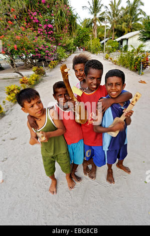 Children with ukulele toys, Arborek, Raja Ampat, West Papua, Indonesia Stock Photo