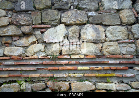 Stone wall with brick frieze. Arhiolagicheska find. Stock Photo