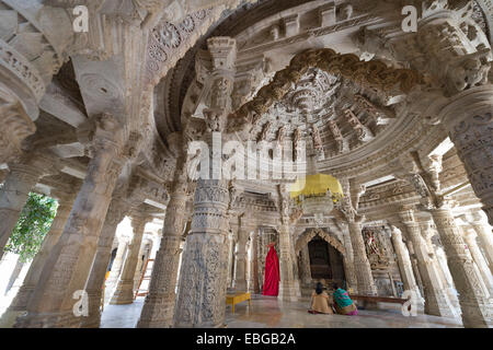 Women sitting in the Interior hall with ornate pillars and ceilings in the marble temple, Adinatha Temple Stock Photo