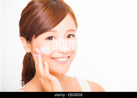beautiful young woman applying cosmetic cream  on her face Stock Photo