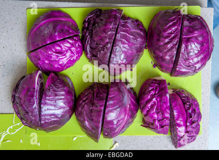Group of red cabbage cut in half on cutting board. Stock Photo