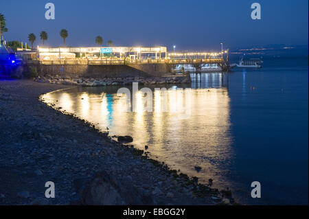 Ligths from a restaurant are reflecting in the water of the Lake of Galilee on the coast of Tiberias Stock Photo