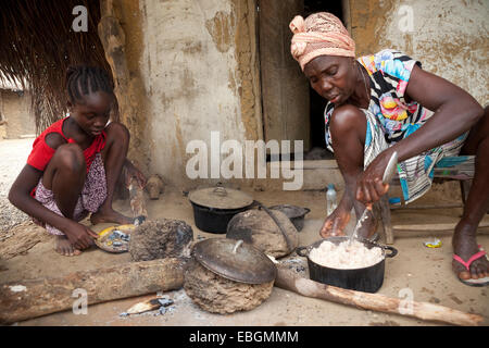 A mother and daughter prepare food together in Kakata, Liberia, West Africa. Stock Photo