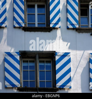 Picturesque fragment of a facade. Windows with striped shutters Stock Photo