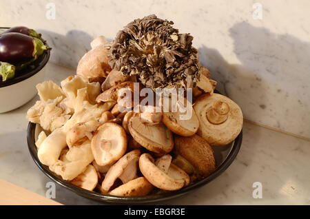 Bowl displaying different kinds of fresh and dry mushrooms Stock Photo