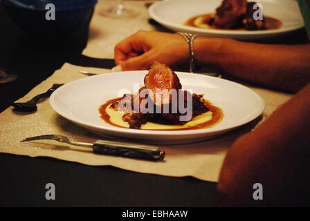 Duck confit served at restaurant table Stock Photo