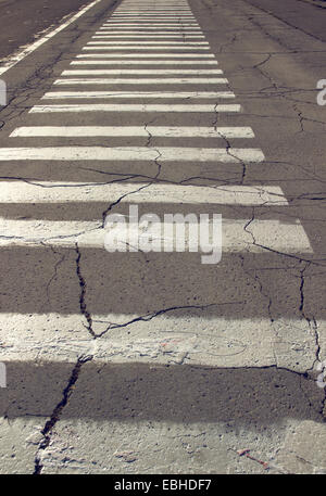 pedestrian zebra crossing, street sign. rough, urban asphalt surface Stock Photo