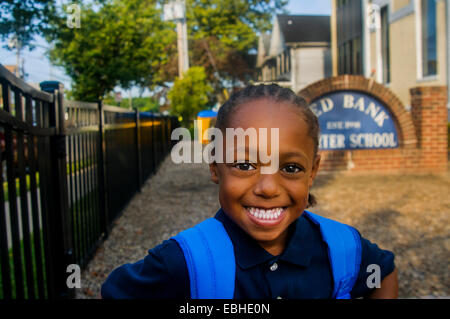 Portrait of smiling schoolboy at school gate Stock Photo