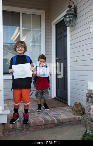 Portrait of two brothers holding up pieces of paper with 3 & 1 Stock Photo