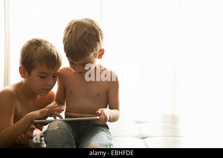 Brothers using digital tablet at home Stock Photo