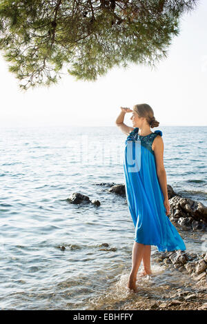 Young woman paddling and gazing out to sea, Milna, Brac, Croatia Stock Photo