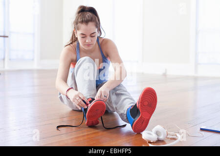 Teenage girl tying trainer laces in ballet school Stock Photo