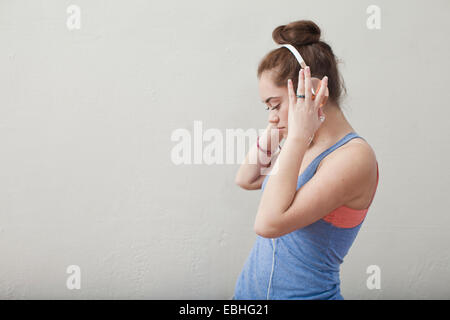 Teenage girl listening to music on headphones in ballet school