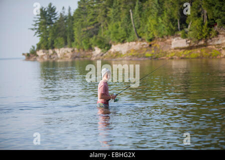 Wading teenage boy fishing in Lake Superior, Au Train Bay, Michigan, USA Stock Photo