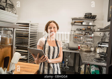 Portrait of female shop assistant with digital tablet in kitchen at country store Stock Photo