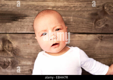 Overhead portrait of baby boy on wooden floor Stock Photo