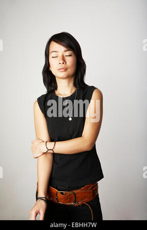 Studio portrait of mid adult woman with eyes closed Stock Photo