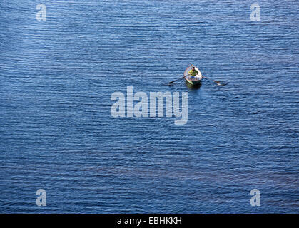 Aerial view of an elderly man rowing a fiberglass rowboat / skiff / dinghy , Finland Stock Photo