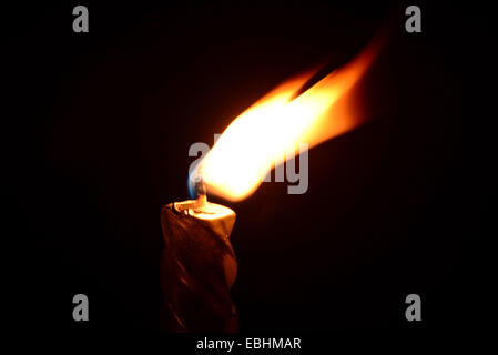 Silver candle burning on a black background Stock Photo