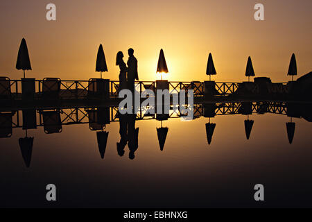 couple by pool at sunset, Fira, Santorini, Greece Stock Photo