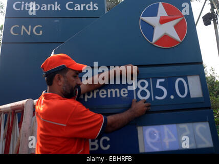 Karachi, Pakistan. 1st Dec, 2014. A Pakistani employee changes the tag of oil price on a board at a gas station in southern Pakistani port city of Karachi on Dec. 1, 2014. Pakistan's Oil and Gas Regulatory Authority (OGRA) drops prices of petroleum products by up to 9 rupees per liter for December. Credit:  Masroor/Xinhua/Alamy Live News Stock Photo