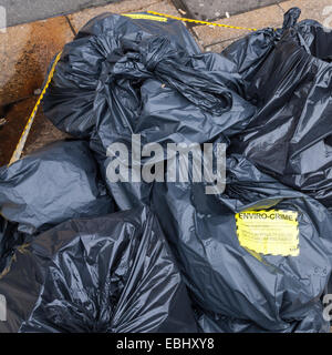 Environmental crime scene. Notice attached to bags of illegally dumped rubbish on a street. Sheffield city centre, England, UK Stock Photo
