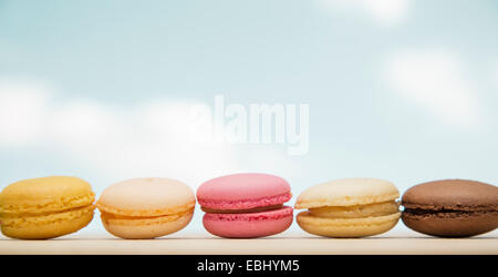 Colorful macaroons, French pastry on sky background Stock Photo