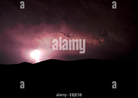 lightning at the night sky over a hill landscape, Greece Stock Photo