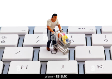 a figure with shopping cart on computer keyboard Stock Photo