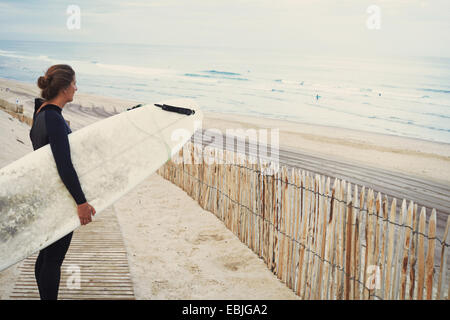 Surfer with surfboard on beach, Lacanau, France Stock Photo