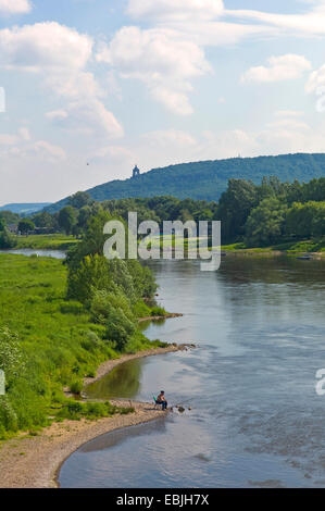 angler at river Weser with the Porta Westfalica with the Kaiser Wilhelm Memorial in the background, Germany, North Rhine-Westphalia, Minden Stock Photo