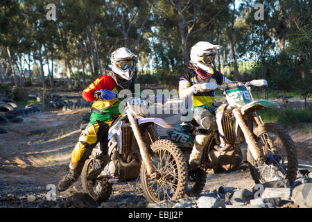 Two young male motocross riders in forest Stock Photo