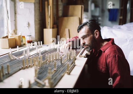 Mature craftsman checking organ pipes in pipe organ workshop Stock Photo