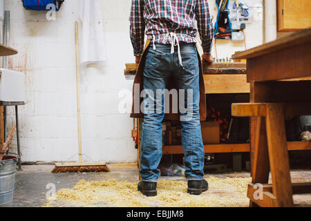 Cropped view of mature craftsman at workbench in pipe organ workshop Stock Photo